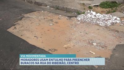 Moradores preenchem buracos com entulhos na Rua do Ribeirão, em São Luís